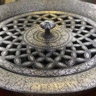Foot warmer, Bidri: Bidri work is black in colour, never fades or rusts, and is inlaid with silver. The alloy used in making Bidri comprises tin and copper in a proportion of 24:1. It was introduced into India [Bidar, Karnataka] from Persia in the 14th Century.
