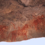 Painters in Bhimbetka oftentimes painted over existing paintings, creating upto 15 layers of superimpositions. The dark ochre compositions belong to the beginning of the Mesolithic period. The compositions in lime are newer in comparison.